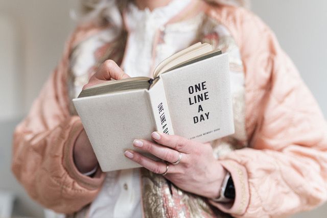 Handen met het boek One Line a Day, symbool voor reflectie en dagboek